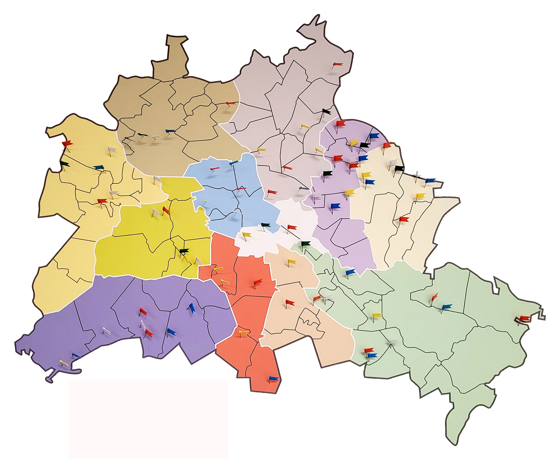 Foto einer Berliner Karte mit farblich markierten Bezirken. Viele Pins kennzeichnen die täglichen Sprechstunden der BuBS in den Unterkünften für Geflüchtete